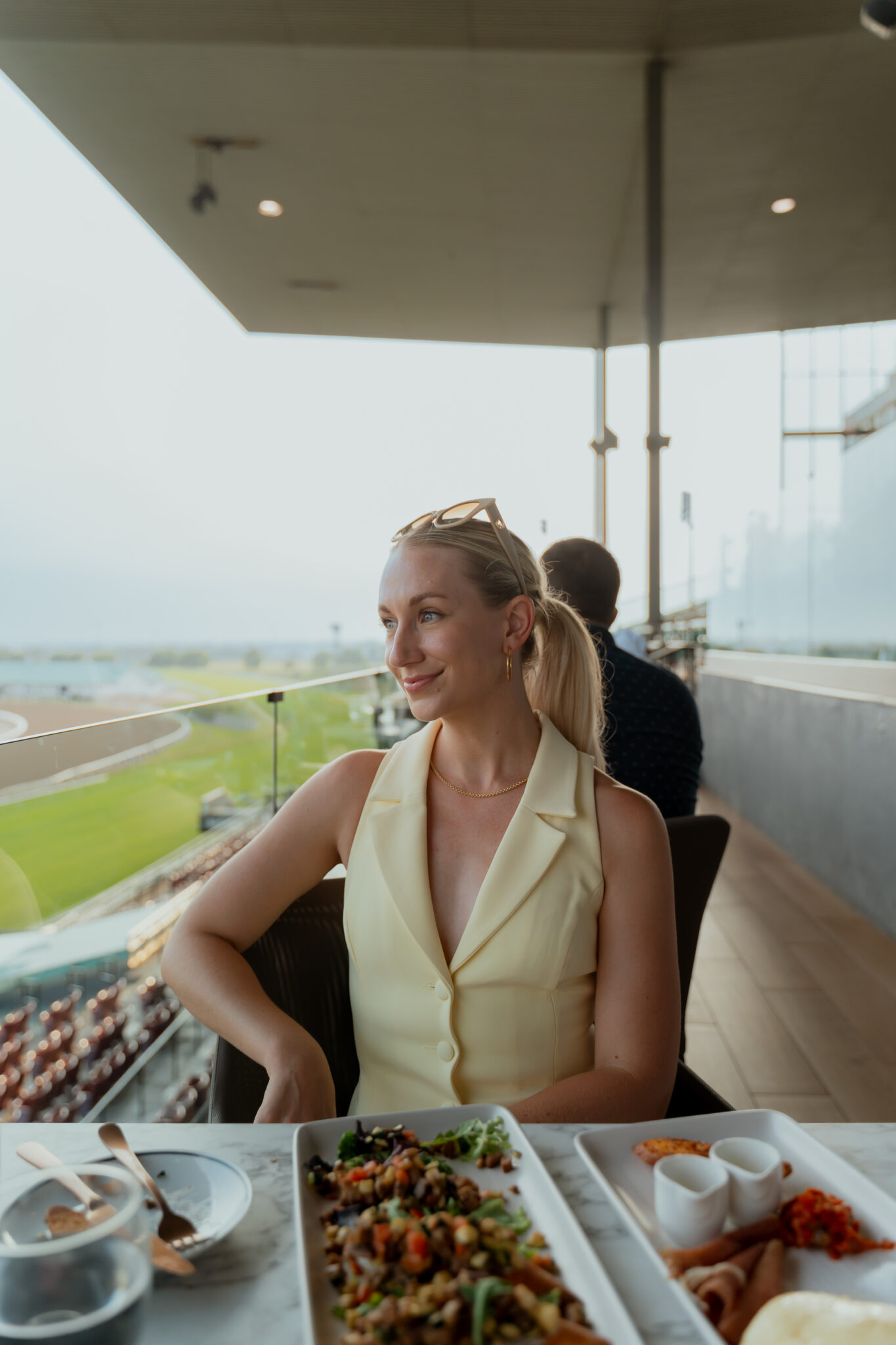 A perfect summer evening at Woodbine Racetrack's Stella Artois Terrace, featuring breathtaking views of horse racing, delicious food and drinks, live jazz music, and an elevated patio experience. Amanda sitting on Patio